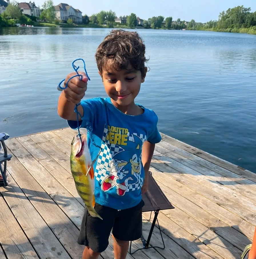 My son holding a fish he caught on the dock